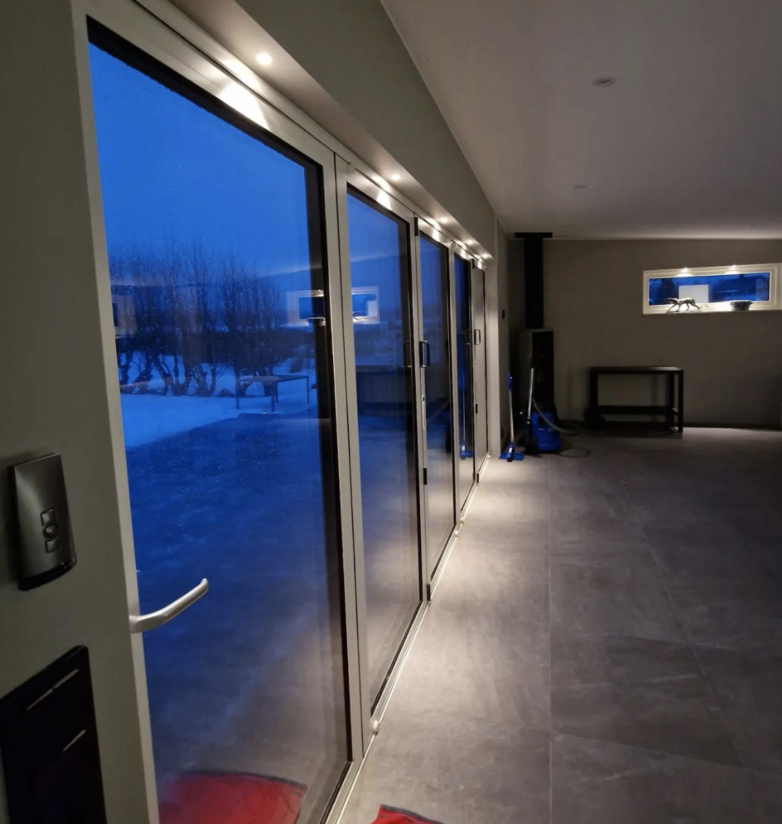 Elektriker från Sveaborg EL AB monterar lampor vid stort fönsterparti i Gävleborg